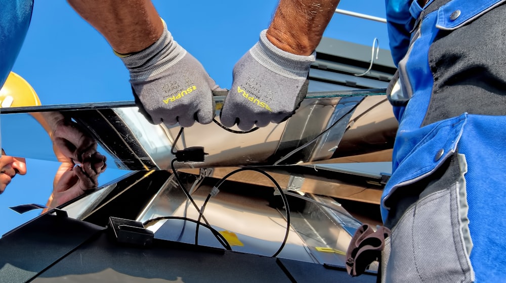 Certified installer mounting solar panels on a roof